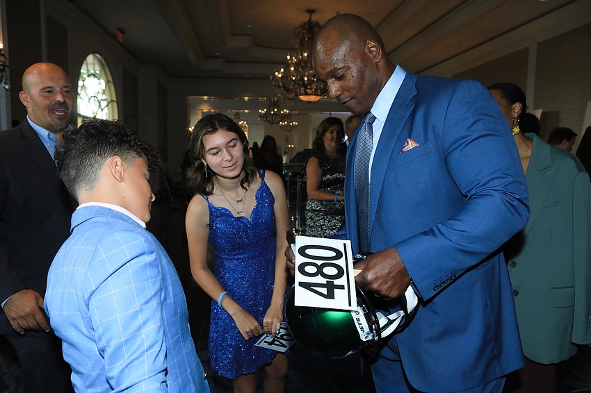 Bryant Young autographs a helmet
