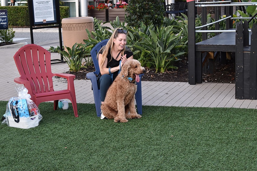 Jessica Lien claps to the music behind Gunner, a Golden Doodle.