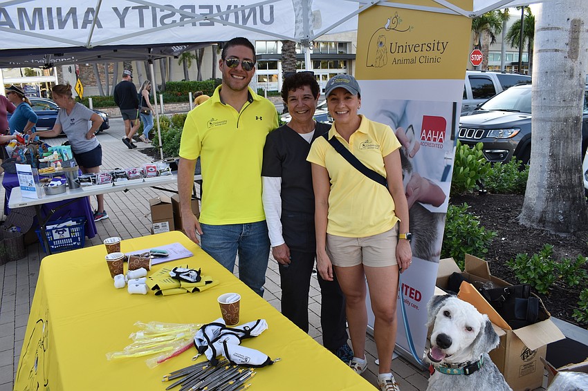 Veterinarian Leigh Samanowitz, Practice Manager Peg Gaven, owner Sam Samanowitz, and Old English Sheepdog Max of University Animal Clinic staff the organization's table.