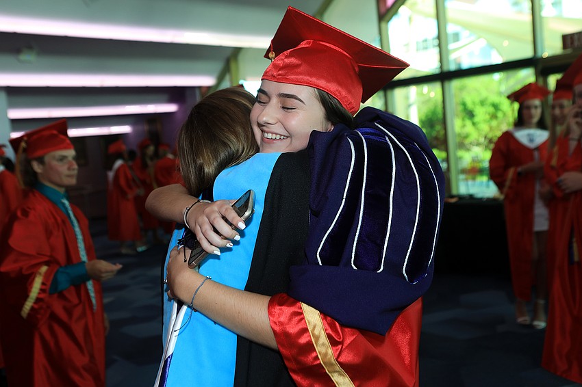 Student government president Delaney Lento hugs teacher Sarah Gates.