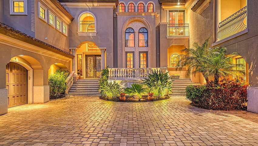 A circular driveway leads to the main entrance and a five car garage.