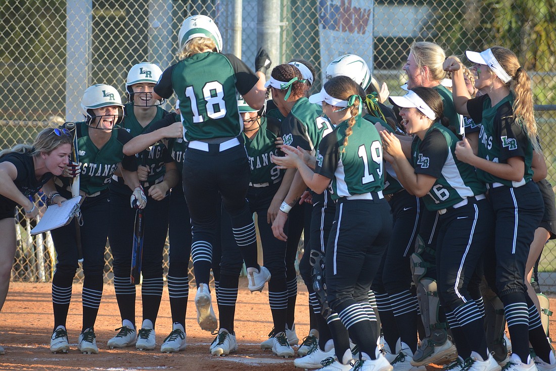 The Lakewood Ranch softball team greets Grace Hogie (18) at the plate following her home run against West Orange High on May 12. Hogie said the team&#39;s confidence on offense is sky high.