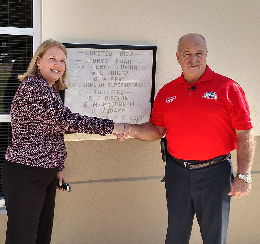 Orange County School Board Member Christine Moore learned District 3 Ocoee Commissioner Rusty Johnson had the plaque and helped to organize its mount.