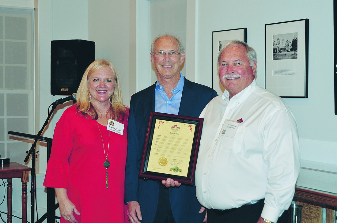 Winter Garden Mayor John Rees, center, presents a proclamation declaring Larry Cappleman a Heritage Builder in the city. Lori Gibson, president of the Winter Garden Heritage Foundation, shared Larry Capplemanâ€™s accomplishments in a program recently.