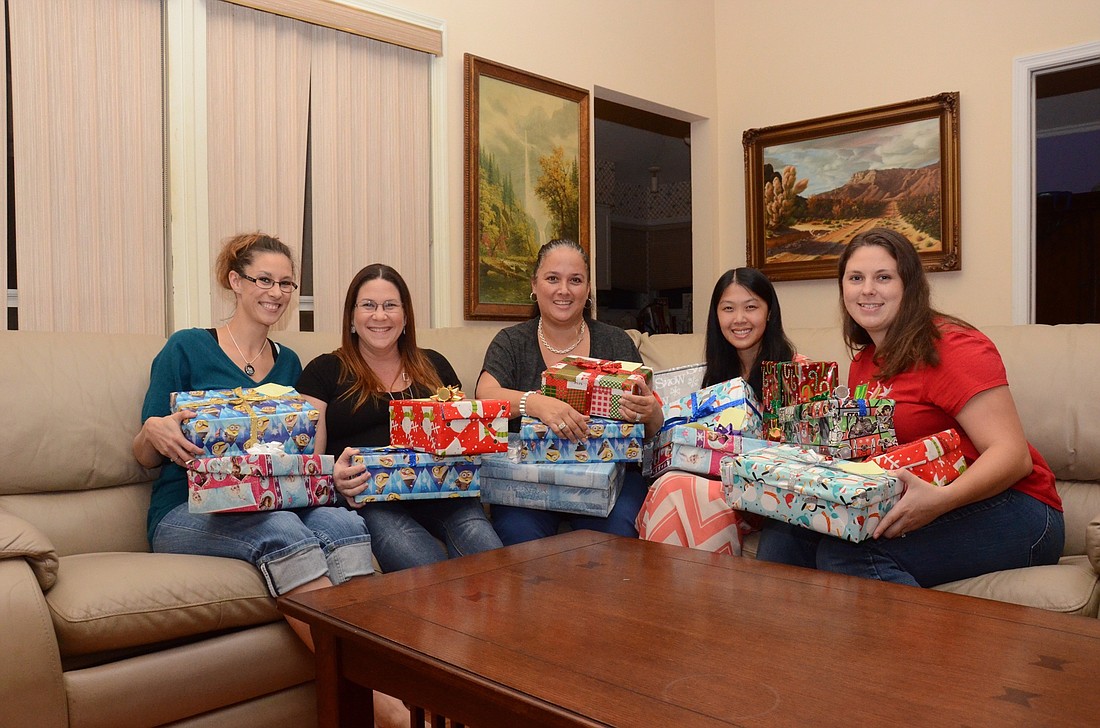Tiffany Ridgley, Danielle Pascucci, Diahann Messeguer, Winnie Harrell and Melinda Thompson are working together to create the boxes for children who are hospital-bound this Christmas.