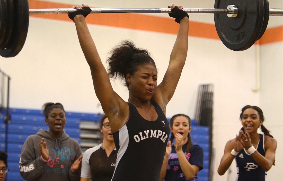 Teammates and competitors alike cheer on Olympia High's Maherley Exvier as she executes a clean-and-jerk lift Jan. 14.