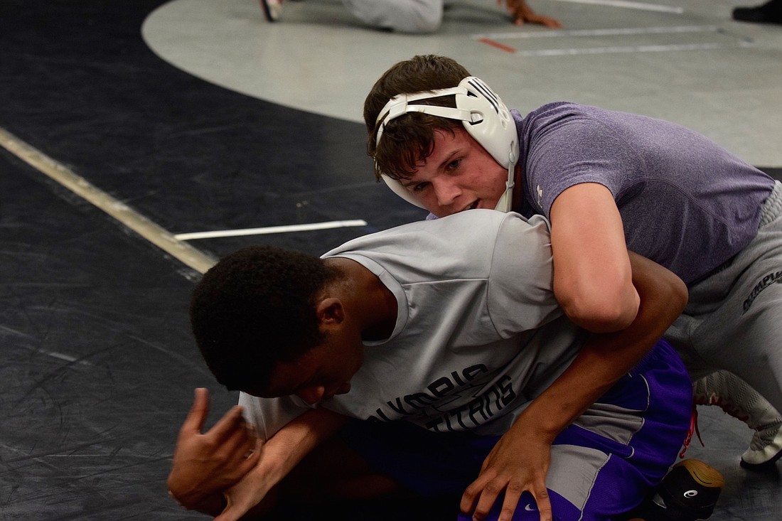 Olympiaâ€™s James Murphy, top, and Muib Akineyle practice live wrestling at a recent practice session.
