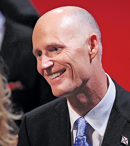 Florida Governor Scott greets an attendee in the audience before the start of the final U.S. presidential debate in Boca Raton