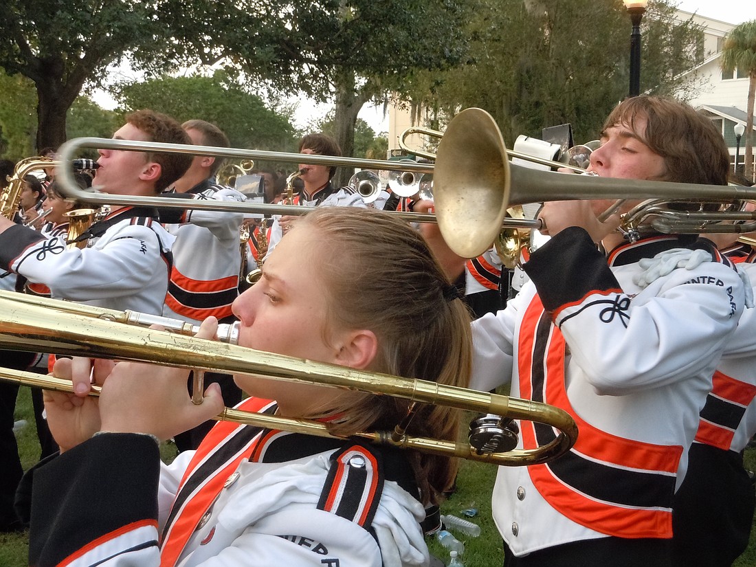 Photo by: Clyde Moore - Winter Park High School's marching band plays down Park Avenue.