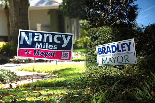 Photo by: Isaac Babcock - Bradley and Miles campaign signs dot city lawns. (Photo illustration)