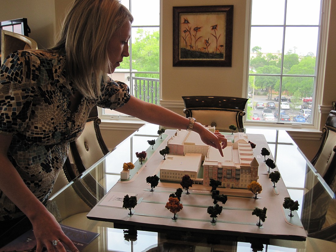 Photo by: Jenny Andreasson - Christine Hodgson, Accelerated Marketing project manager, uses a model of the Douglas Grand at Winter Park to point out where the 14 auction units are located.