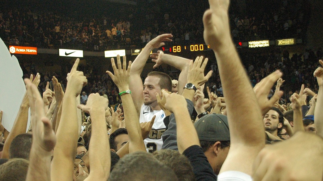 Photo by: Isaac Babcock - Knights fans lift captain A.J. Rompza as they mob the court after Knights beat Memphis 68-67 on Jan. 18.