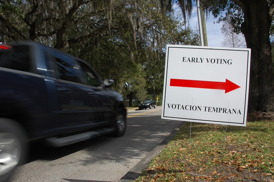 Photo by: Isaac Babcock - Cars pass by an early voting sign at the Winter Park Library.