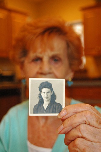 Photo by: Isaac Babcock - Holocaust survivor Helen Greenspun holds a photograph of herself from 1946 when she was in a displaced persons camp after being liberated from a concentration camp in Germany.
