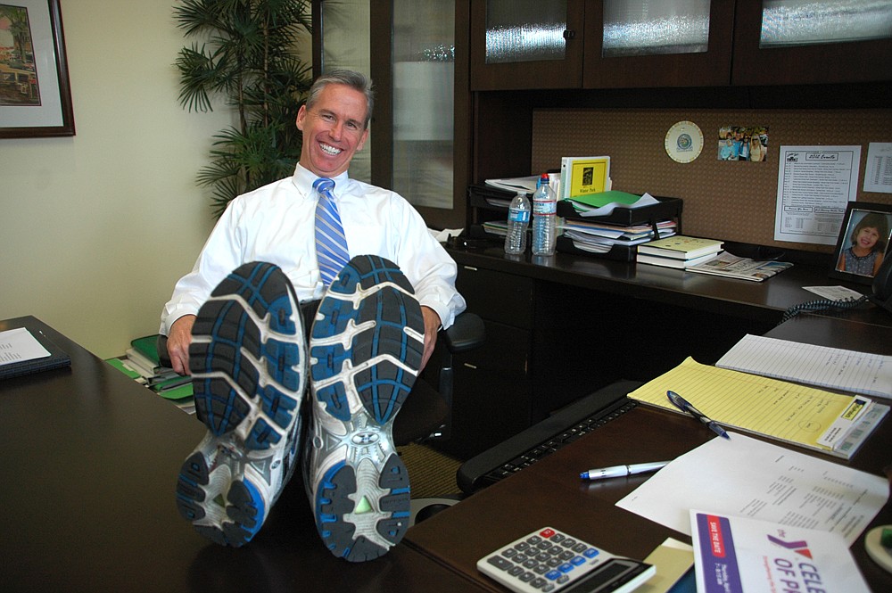 Photo by: Isaac Babcock - Winter Park Chamber of Commerce President Patrick Chapin shows off the running shoes he wears in the office as part of the Work Well Winter Park initiative.