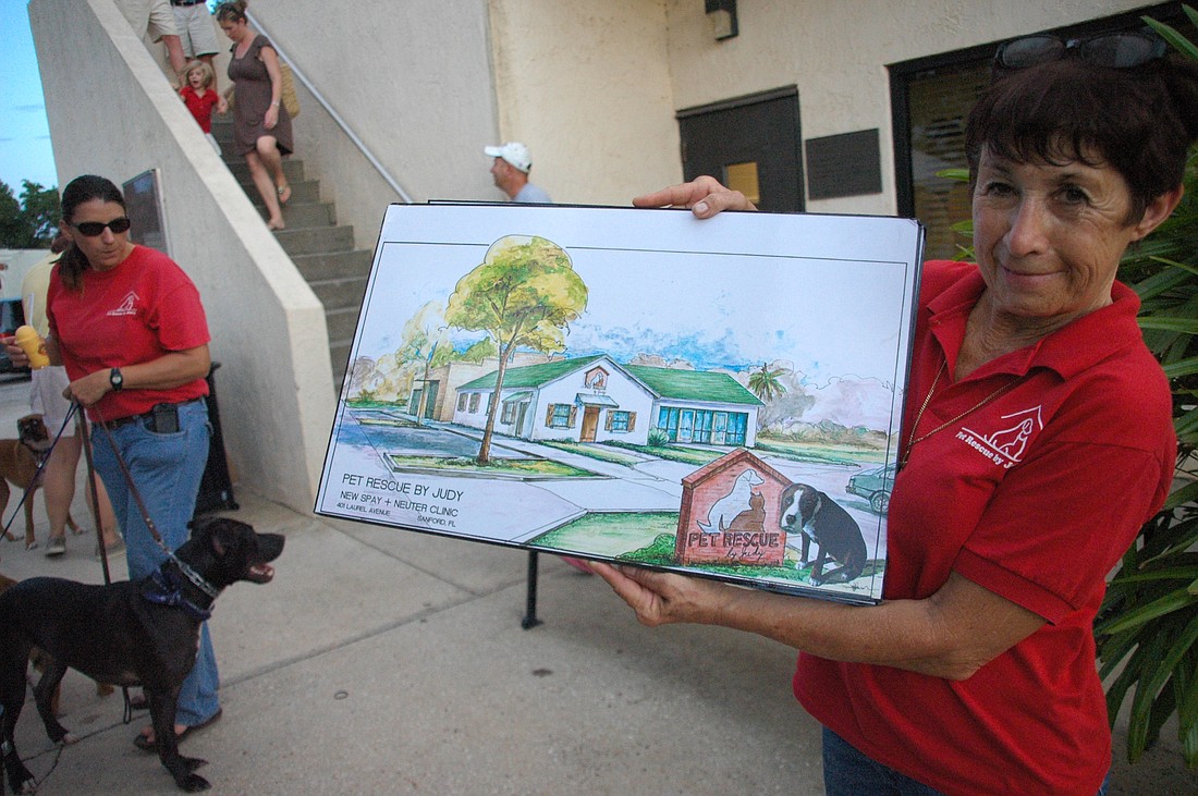 Photo by: Isaac Babcock - Pet Rescue by Judy's Judy Sarullo shows off design plans for a new pet rescue center. She was at the Winter Park Diamond Dawgs game to help raise money to begin construction.