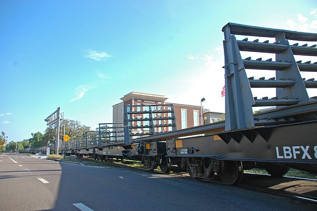 Photo by: Isaac Babcock - Rail cars carry new rails through Maitland to stops where the SunRail system will add additional tracks.
