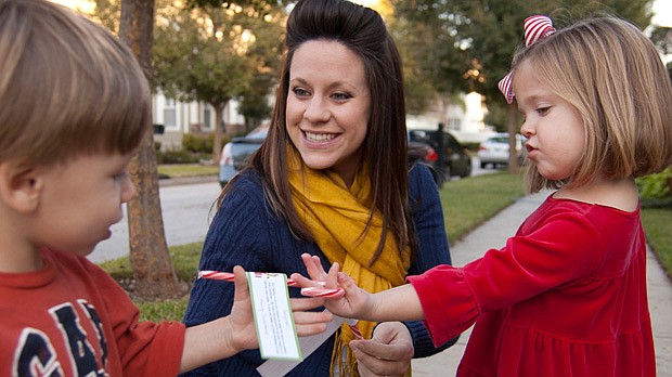 Photo by: Isaac Babcock - Larson Defeo, right, hands a candy cane to Jackson Werner (with mother Andrea), part of a