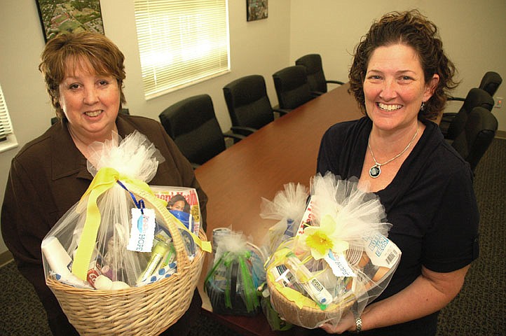 Photo by: Isaac Babcock - Gathering Hope's Brenda Moody, left, and Dawn Payment put together useful gift baskets for families who are caring for dying loved ones.
