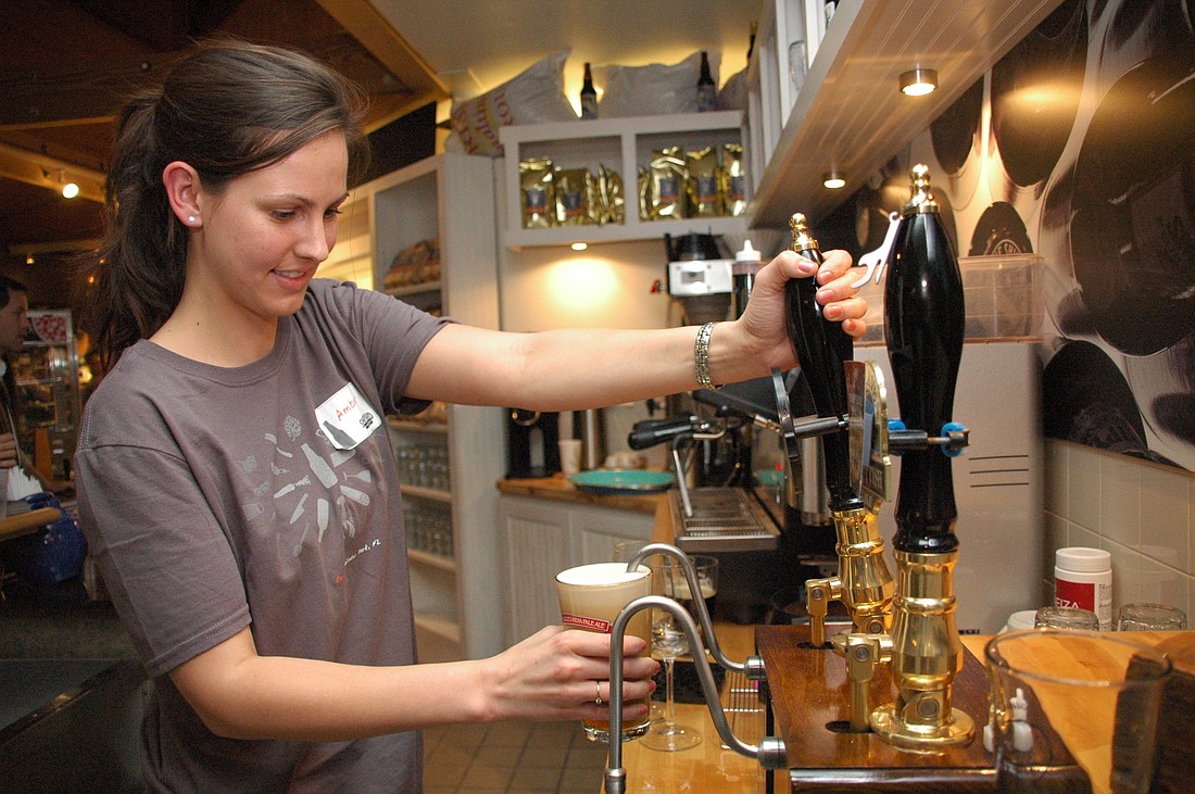 Photo by: Isaac Babcock - Bartender Amber Leenstra pours an Old Thumper at the Shipyard Emporium during the Maine-based brewery's grand opening on Friday night, Jan. 29, on Fairbanks Avenue. The market and brewhouse offered $2 beers and free samples o...