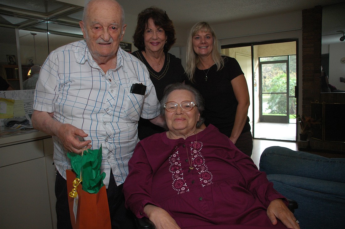 Photo by: Isaac Babcock - Judy Fraden, back center, delivers food to Joe and Greta Zollman, pictured with caretaker Roxanne Efing, for Thanksgiving.