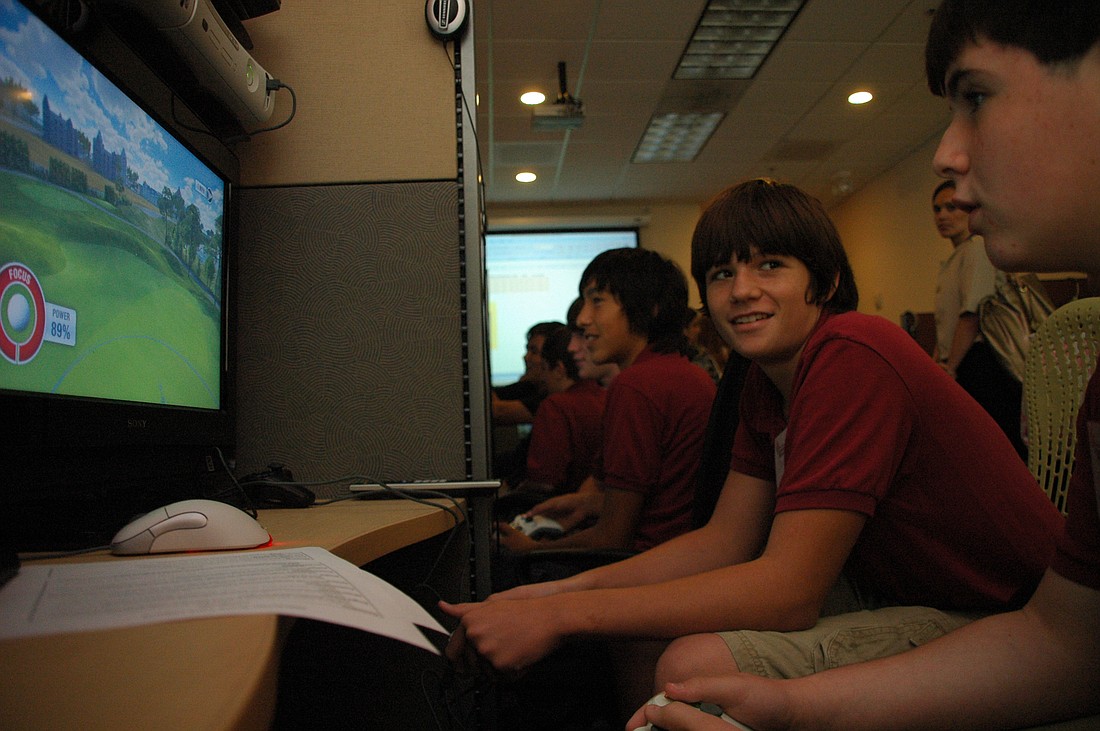 Photo by: Isaac Babcock - Jacob Dunagan, left, and Cody Hurtnagel, 13, test out a golf video game at Electronic Arts Tiburon Studios in Maitland.