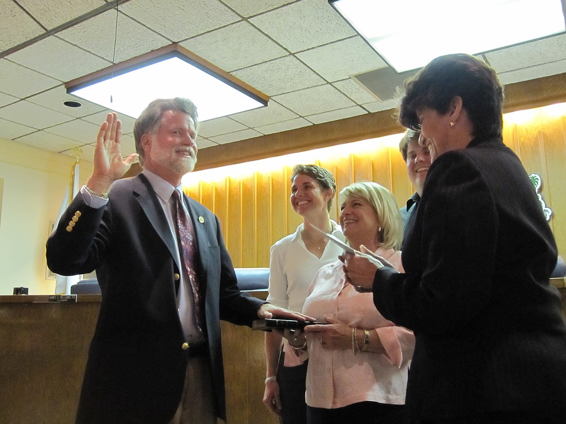 Photo by: Jenny Andreasson - Maitland City Councilman Howard Schieferdecker takes his oath of office in April, as his family looks on. In Maitland and Winter Park, officials are limited to two terms.