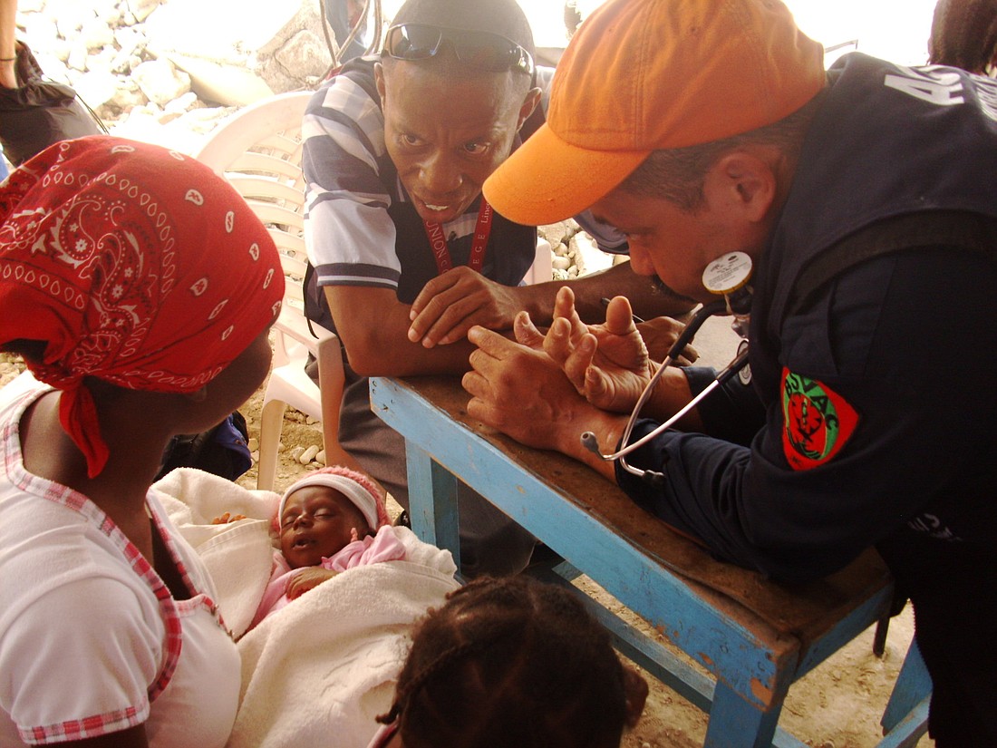 Photo courtesy of Emily Tallman - After hours of waiting, a Haitian woman's newborn is examined by workers at a clinic days after the Jan. 12 earthquake.