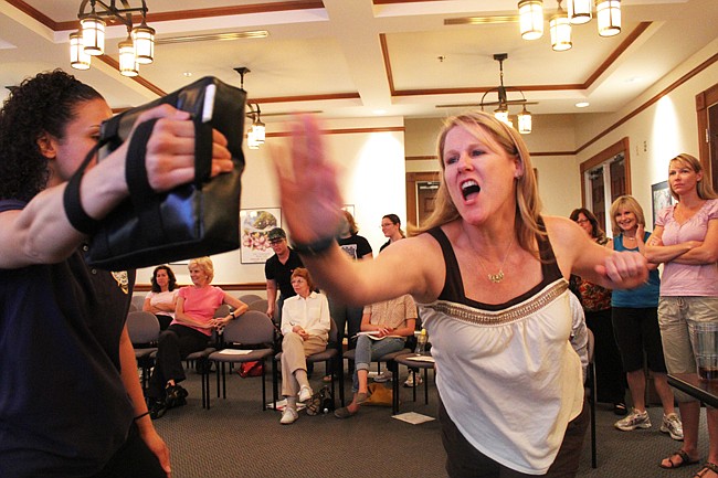 Photo by: Rebecca Males - Heidi Dotson takes a swing at Kaitlin Gonzalez at a SAFE self defense class offered by the Winter Park Police Department.