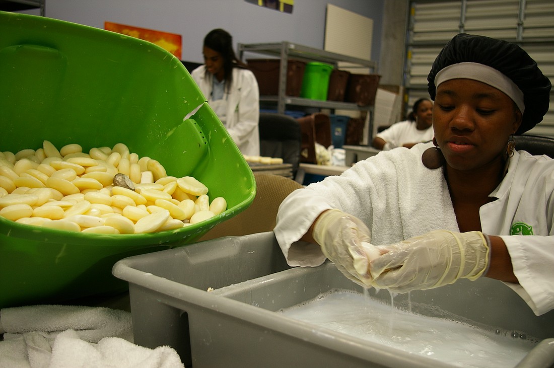 Photo by: Megan Stokes - Letia Green, 18, of Workforce Central Florida, scrapes and rinses bars of soap donated to Clean the World.