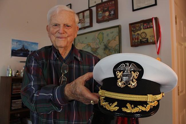 Photo by: Sarah Wilson - Retired Navy Cpt. Robbie Roberts stands in front of memorabilia from his years in the U.S. Navy during World War II and beyond. Roberts is one of only 1 million remaining living World War II veterans of the 16 million American...