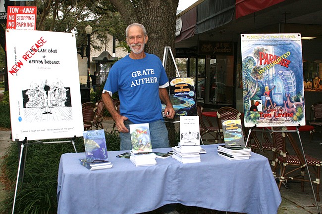 Photo by: Allison Olcsvay - Tom Levine sets up shop at a table just outside Cigarz on the Avenue in Winter Park, where he sells his eccentric novels.