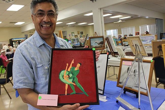 Photo by: Sarah Wilson - Emerging artist Victor Pagan poses with his first foray into painting on canvas, a portrait of ballerinas mid-dance.
