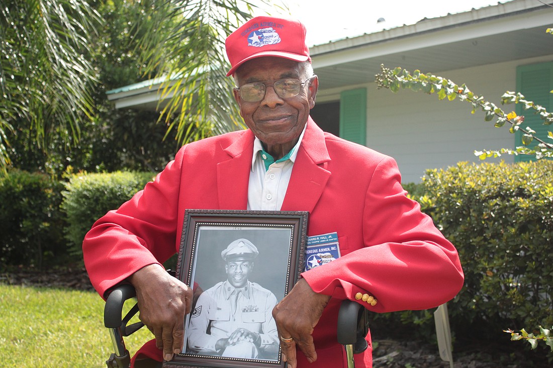 Photo by: Steven Barnhart - Richard Hall Jr., 88, sits outside his Maitland home and holds a photo taken of him in his days as a Tuskegee Airmen pilot fighting in Europe.