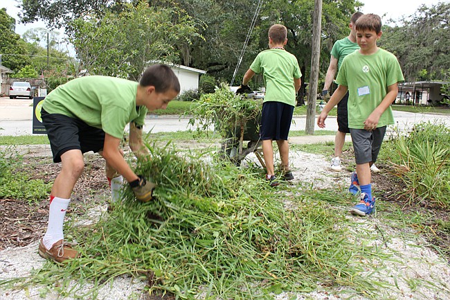 Photo by: Sarah Wilson - Volunteers work to clear a water flow area in Mead Garden June 23.