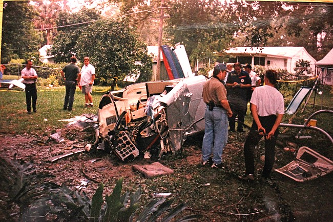 Photo by: Stuart Culley - Investigators pore over the aftermath of a helicopter crash in the backyard of a Winter Park home in 1997. Survivors recalled their experiences 15 years later.