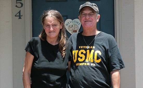 Photo by: Allison Olcsvay - Former marine Dennis Sinns and girlfriend Rhonda Weaver stand in front of their new home, after living in tents for years before a program helped them.