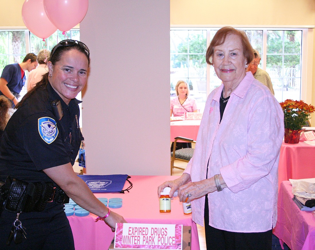 Winter Park Police Officer Lina Strube collects expired medications from Mayflower resident Carol Service.