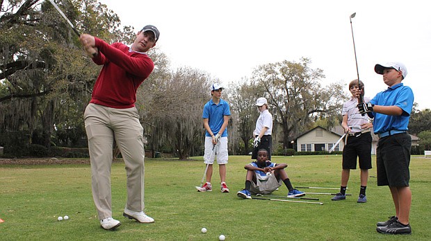Photo by: Sarah Wilson - Thomas Lawrence shows kids the perfect swing at a First Tee golf clinic at Winter Park Country Club.