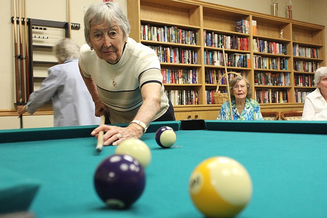 Photo by: Sarah Wilson - Eight ladies in their 80s and 90s gather weekly to practice their skills at the pool tables at the Village on the Green community in Longwood.