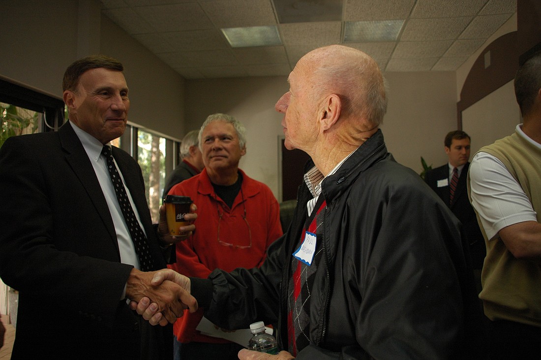 Photo by: Isaac Babcock - U.S. Rep. John Mica, left, shakes hands with constituents in Maitland on Saturday. He was in town on a trip to chat with residents.