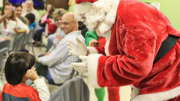 Photo by: CENTER FOR INDEPENDENT LIVING - Santa Claus said hello with sign language at a Christmas party for deaf clients Dec. 13.