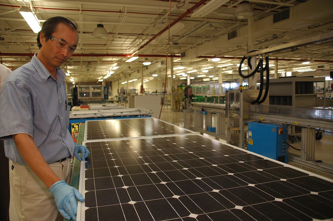Photo by: Isaac Babcock - Senior Engineer Dustin Pham inspects a photovoltaic panel at BlueChip Energy's solar panel factory in Lake Mary. With the impending loss of incentives to customers, solar energy is hoping for extended rebates.