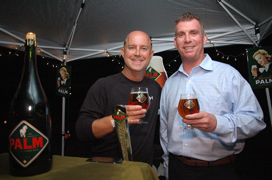 Photo by: Isaac Babcock - Serving up holiday cheer, beer distributors Chuck Hatcher from Schenck Company and Chris Graves from Latis Imports smile for the camera at the Taste of Maitland Monday night.