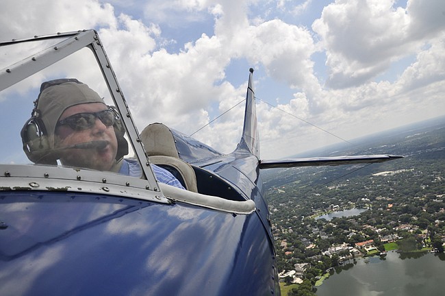 Photo by: Isaac Babcock - Pilot Rick Blyseth surveys the skies in Miss Liberty, now taking to the air at Florida Biplanes, which just launched in Orlando. The tour company lets guests choose their own adventures in a WWII-era biplane.
