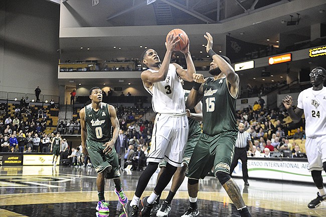 Photo by: Isaac Babcock - Knights forward A.J. Davis drives to the basket amid a crush of USF defenders during the Knights' 75-64 win on Jan. 6. They face ECU on Saturday.