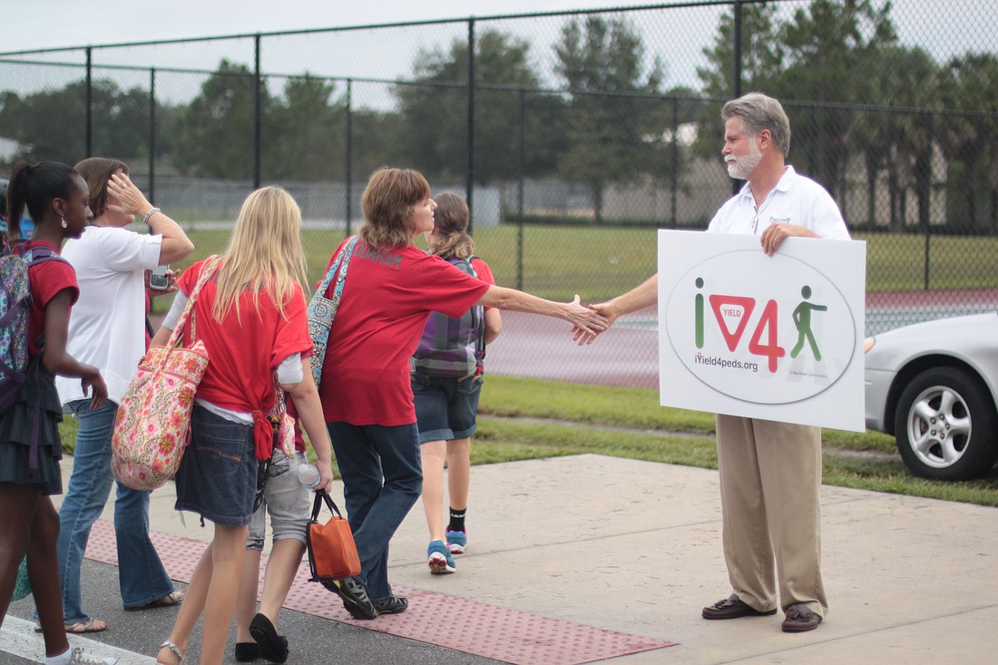 Photo by: Steven Barnhart - Maitland Mayor Howard Schieferdecker shakes hands with parents and students during Walk to School Day Oct. 3.