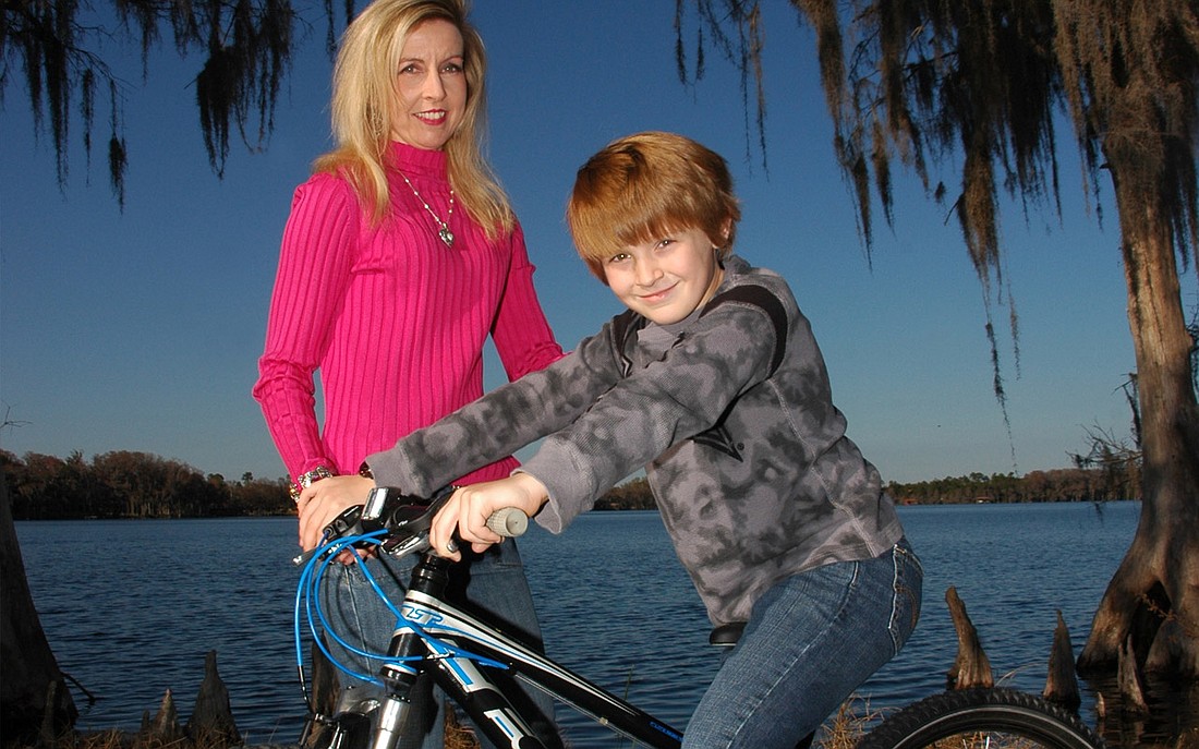 Photo by: Isaac Babcock - Mala Barrett poses with son Luke at Lake Baldwin. They are volunteers for the Bike for a Cure event on Saturday, March 12 in Hannibal Square.