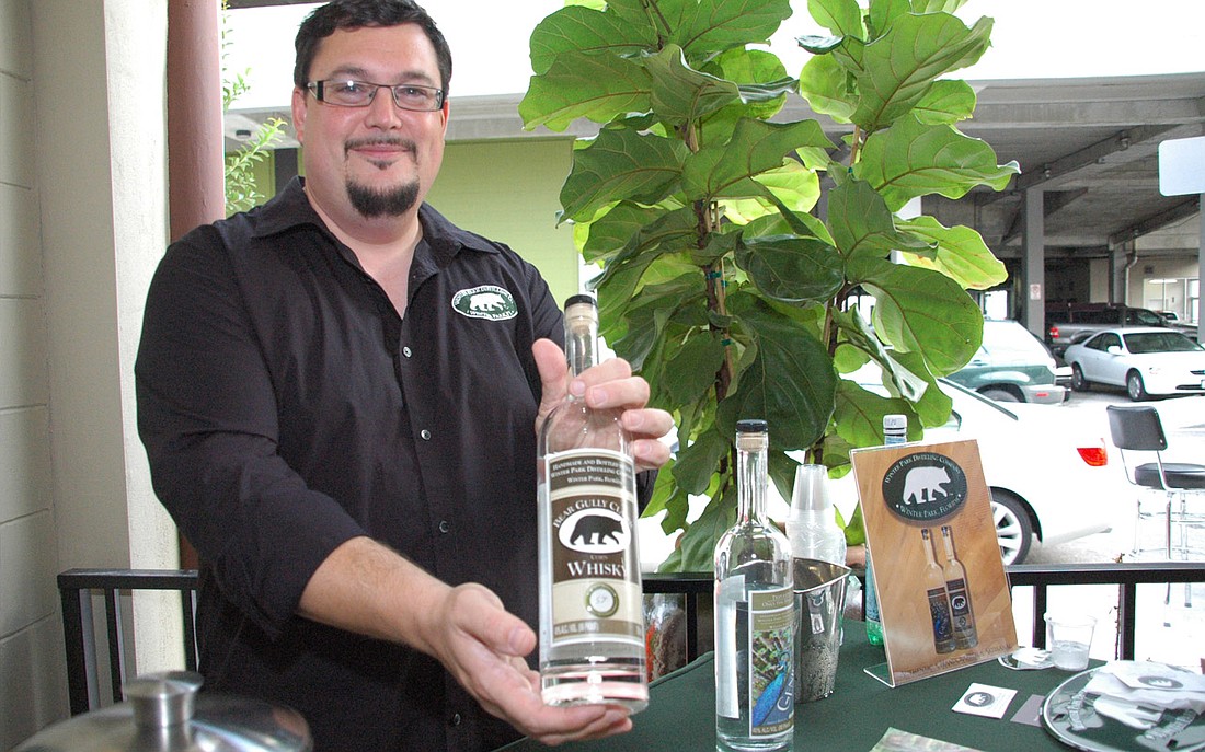 Photo by: Isaac Babcock - Winter Park Distilling President Paul Twyford shows off his company's new clear whiskey at the grand opening of Cocina 214 on Thursday, May 5, in Winter Park.