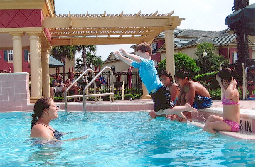 Photo courtesy of Sharks and Minnows - A child jumps off the edge of the pool deck into the arms of his awaiting Sharks and Minnows swim instructor.